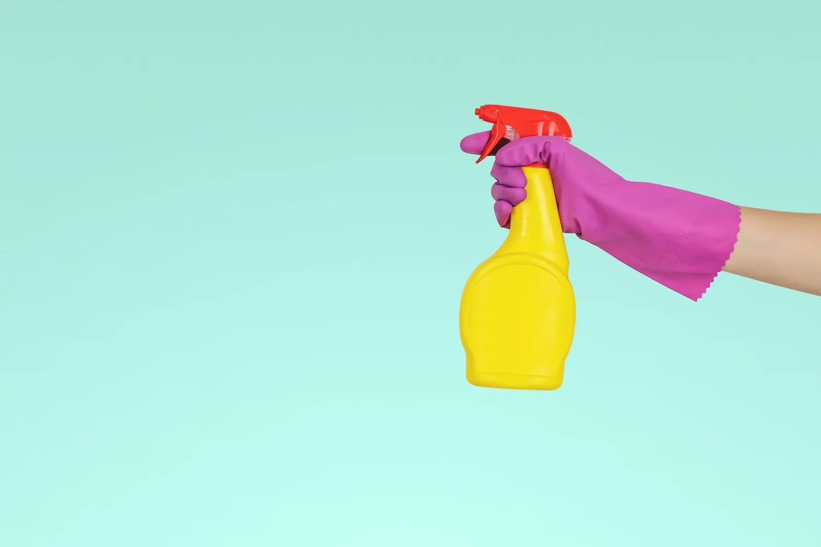 person holding yellow plastic spray bottle - Air Purifiers For People With Chemical Sensitivities
