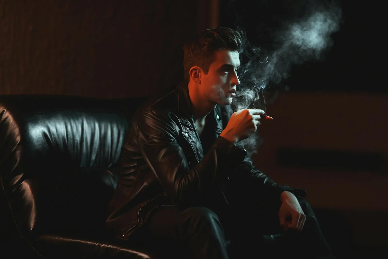 Man Holding Cigarette While Sitting on Sofa - remove air pollutants